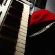 DJ BAD THA PROBLEM with a red hoodie and black and grey hat on. Leaning up against a grey midi keybo